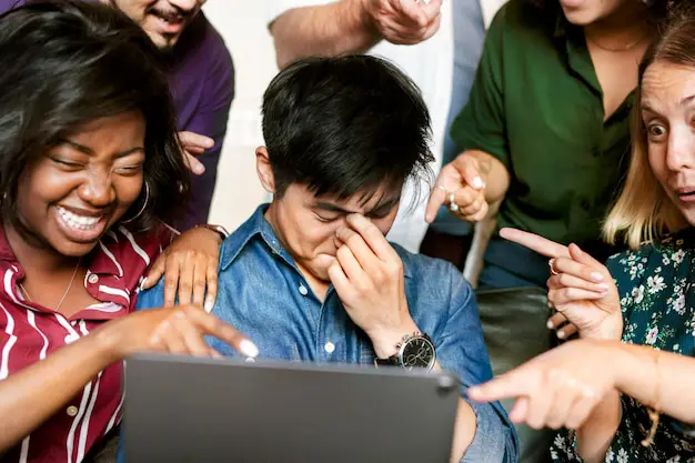 Menikmati anime bersama Sebuah kelompok orang beragam sedang menonton anime di tablet